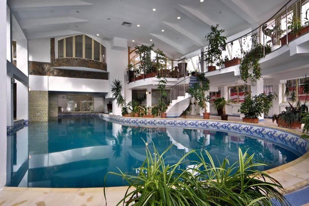 Ein Innenpool mit einer zentralen Treppe, umgeben von Balkonen mit Topfpflanzen.