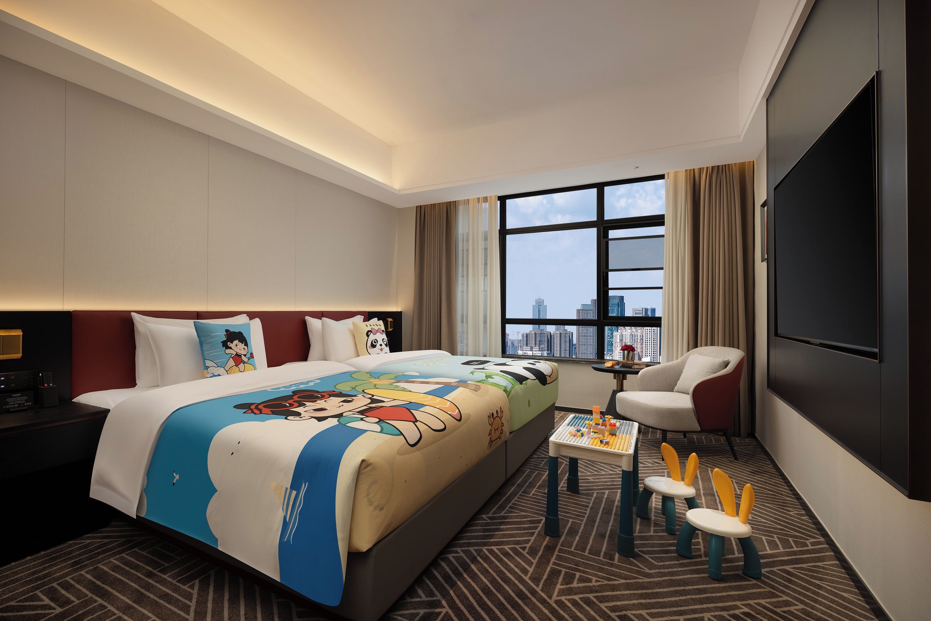 A hotel room with a large bed, a TV, a desk with a chair, and a view of a cityscape.