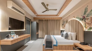 A modern hotel room with a bed, bedside table, desk, and a flat-screen TV. - Hotel Highway King (Jaipur)