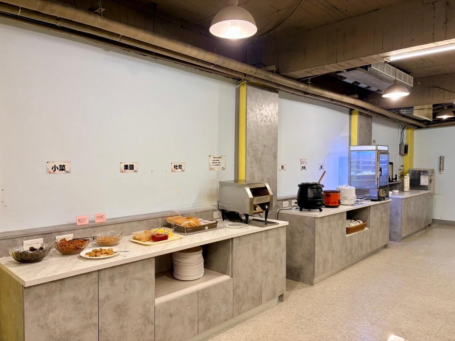 A food service area with multiple counters, each with a variety of dishes and a digital ordering system.