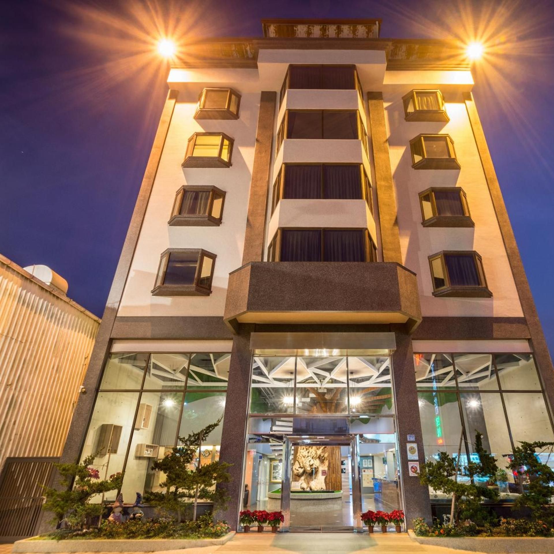 A multi-story hotel with a central entrance, large windows, and a modern design.