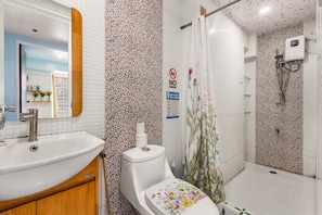 Ein Badezimmer mit Waschbecken, Toilette, Dusche und Spiegel.