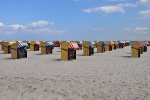 A beach with rows of wooden beach huts with striped awnings. - House Sorgenfrei Holiday Home No. 7 (Travemünde)