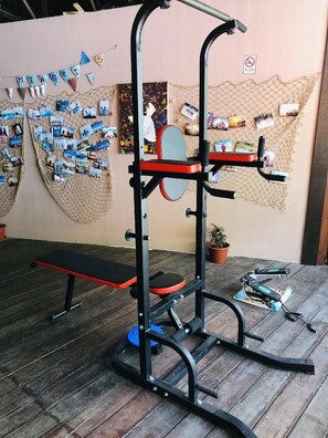 A home gym with a bench press, a squat rack, and a pull-up bar. - Gayang Friendly Water House Homestay (Tuaran)