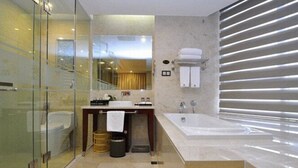 Een moderne badkamer met een douchecabine van glas, een wastafelmeubel en een apart badgedeelte.