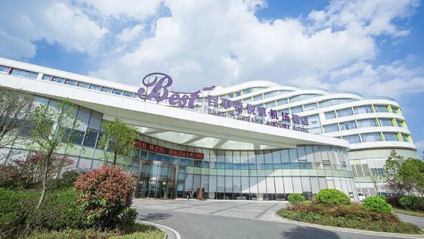 Een modern hotel met een gebogen gevel en grote ramen.