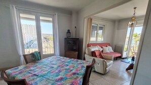 Una habitación con una mesa de comedor, un sofá y un televisor.