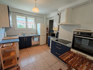 A kitchen with a dishwasher, oven, and a window with a view of buildings. - L'Escale du Suffren - View of the Harbor - Toulon (Toulon)