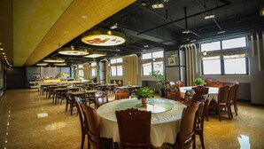 A spacious dining area with multiple round tables and chairs, large windows, and a high ceiling with exposed beams. - Homeinn Superior Hotel (Hefei)