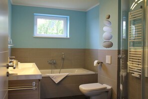 A bathroom with a bathtub, toilet, and sink. - Holiday apartment with 1 bedroom (Börgerende)