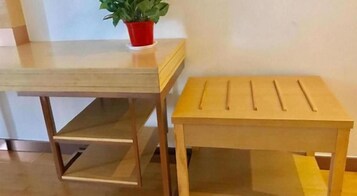 Dos mesas de madera con estantes, una con una olla roja encima.