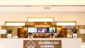 A reception desk with a sign reading 'GreenTree Inn' and multiple monitors above it. - Greentree INN Huaibei Xiangshan District Guogou Square Hotel (Huaibei)