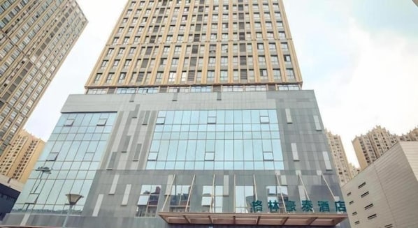 Ein Hochhaus mit moderner Glasfassade und einem markanten Eingang.