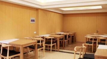 Un salón de conferencias con varias mesas y sillas dispuestas en filas.
