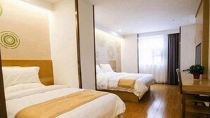 A hotel room with two beds, a wooden floor, a small table, and a window with curtains. - Greentree INN Huaibei Xiangshan District Guogou Square Hotel (Huaibei)