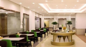 Un vestíbulo de hotel con mostrador de recepción, zona de estar y un espejo grande.