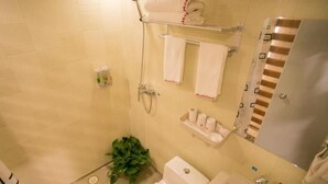 Une salle de bain équipée d’une douche, de toilettes, d’un lavabo et d’un porte-serviettes.