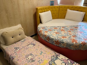 A room with two beds, one with a floral bedspread and the other with a Hello Kitty theme. - Sunshine Hotel (Kowloon)
