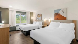 A hotel room with two beds, a desk, a window with curtains, and wall-mounted lights. - Casco Bay Inn (Freeport)