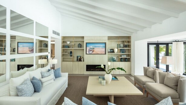 A modern living room with a white sofa, a coffee table, and a TV mounted on the wall. - Vrbo Property (Marbella)