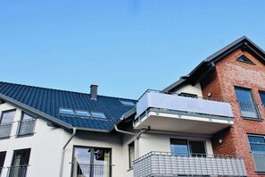 A multi-story residential building with a flat roof, balconies, and a brick facade. - Holiday apartment with 2 bedrooms (Zingst)