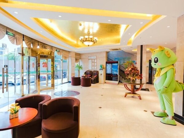 Vestíbulo de hotel con mostrador de recepción, zona de estar y una mascota.