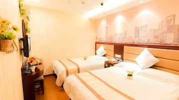 A hotel room with two beds, a desk with a computer, a TV, and a wall mural.