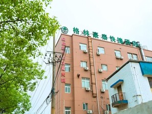 A multi-story building with a sign indicating it is a hotel. There are multiple windows on the facade, and the building has a flat roof.