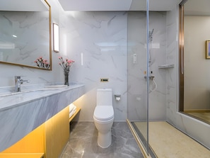 A modern bathroom with a marble vanity, a toilet, and a glass-enclosed shower. - Vienna International Hotel (Huanggang)