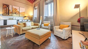 A modern living room with a sofa, armchair, ottoman, and a small table.