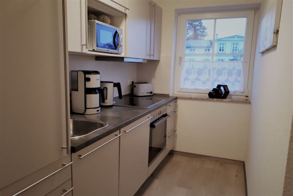 A compact kitchen with a microwave, coffee maker, toaster, and oven.