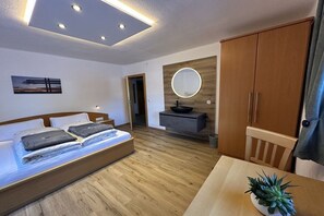 Een moderne slaapkamer met een bed, nachtkastje en spiegel.