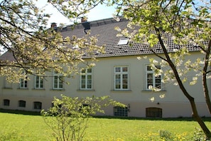 A two-story building with a symmetrical facade, multiple windows, and a flat roof. - Old Rectory Elmenhorst (Elmenhorst)