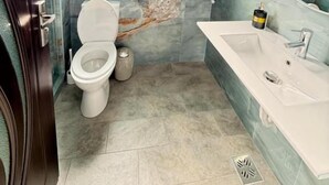 Un baño con inodoro, lavabo y ventana.