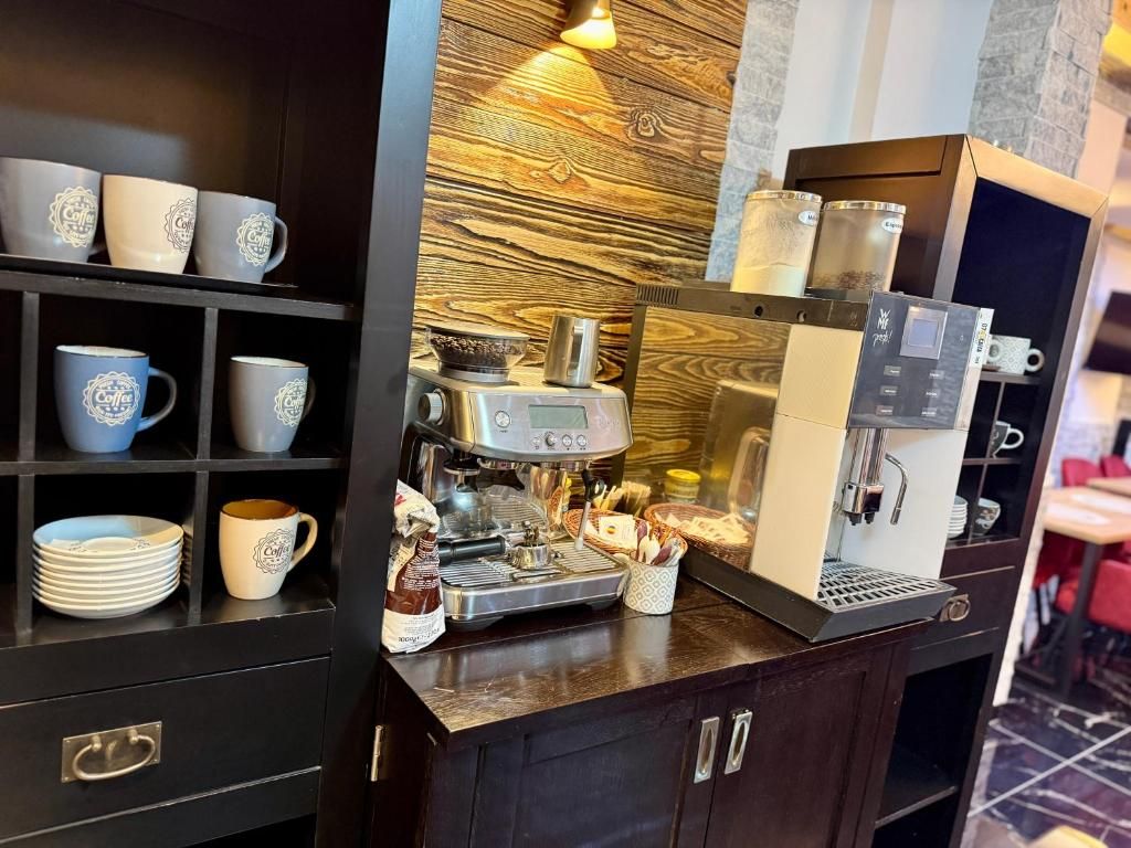 Kahvinurkkaus, jossa on espressokone, kuppeja ja vitriini.