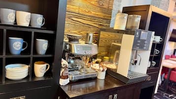 Kahvinurkkaus, jossa on espressokone, kuppeja ja vitriini.
