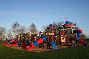 Ein Spielplatz mit Rutschen und Klettergerüsten.