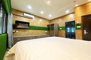 A hotel room with a bed, a flat-screen TV mounted on the wall, an air conditioning unit, a wardrobe, and a door with a keypad lock. - OYO 90262 Kota Kinabalu Homestay, Villa & Suite Boutique (Kota Kinabalu)