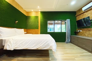 A bedroom with a bed, a dresser, a TV mounted on the wall, and a window with curtains. - OYO 90262 Kota Kinabalu Homestay, Villa & Suite Boutique (Kota Kinabalu)