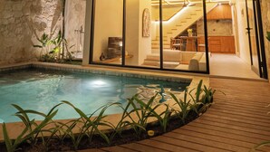 Una casa moderna con piscina, una escalera que lleva al piso superior y vistas del interior a través de amplios ventanales.
