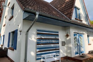 A building with a white facade, blue shutters, and a nameplate reading 'MARITMA'. - Holiday home with 3 bedrooms (Ostseebad Prerow)