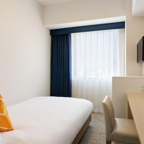 A hotel room with a bed, a desk, and a chair. There is a window with curtains. - Unizo INN Express Utsunomiya (Utsunomiya)