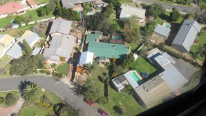 Luchtbeeld van een woongebied met huizen, wegen en begroeiing.