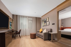 A hotel room with a bed, a sofa, a desk, and a television. - Hilton Huiting Xishuangbanna Jinghong (Xishuangbanna Dai)