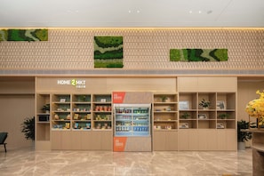 A retail store with a variety of products on shelves and a refrigerated section. - Hilton Huiting Xishuangbanna Jinghong (Xishuangbanna Dai)