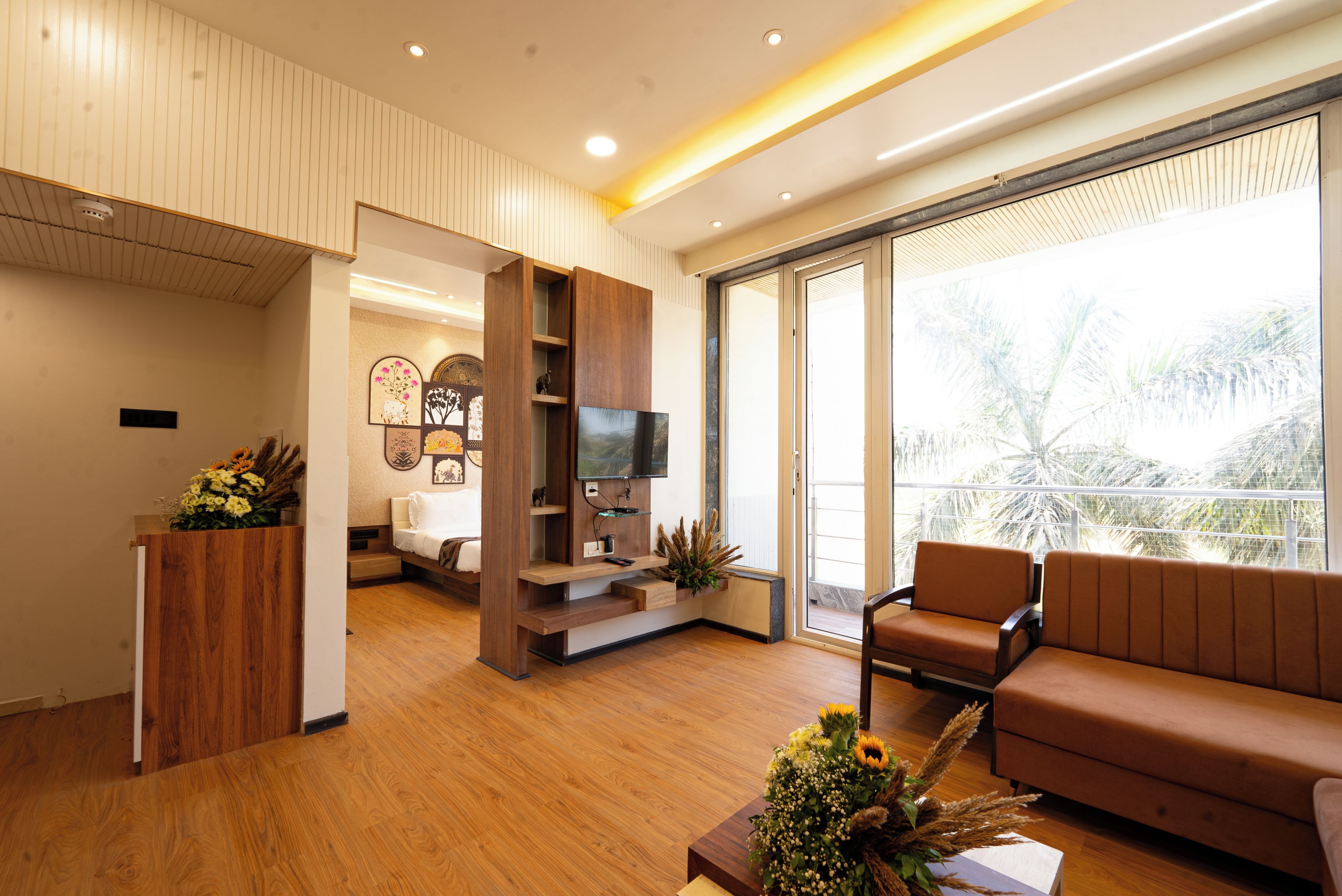 Una sala de estar moderna con piso de madera, un sofá, un televisor y un balcón con vistas.