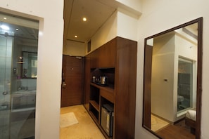 A compact bathroom with a mirror, a sink, and a shower area.