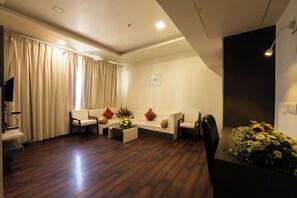 A modern living room with a sofa set, a coffee table, and a TV stand. - Manish Aura Grand (Vadodara)