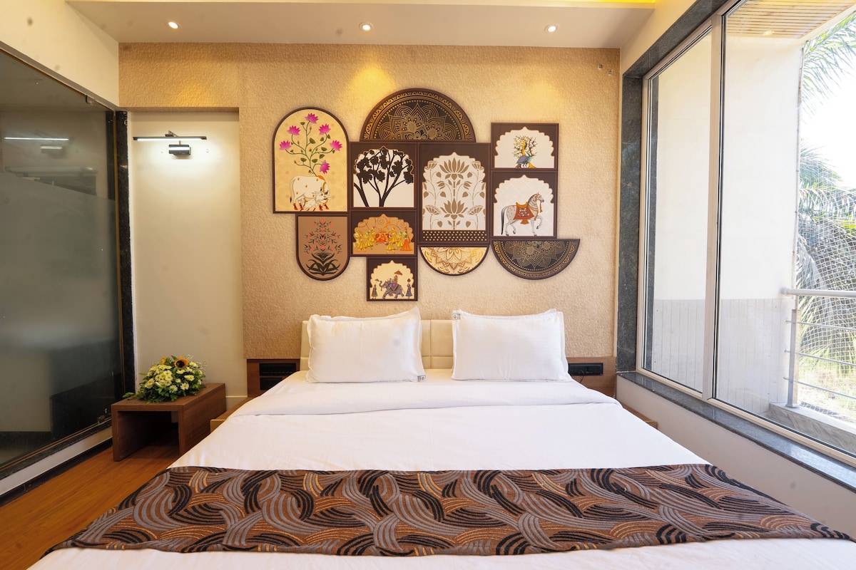 Ein Hotelzimmer mit einem großen Bett, einer Wand mit dekorativen Paneelen, einer kleinen Pflanze und einem Fenster mit Ausblick.