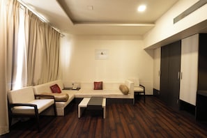 A modern living room with a sofa set, a coffee table, and a cabinet. - Manish Aura Grand (Vadodara)